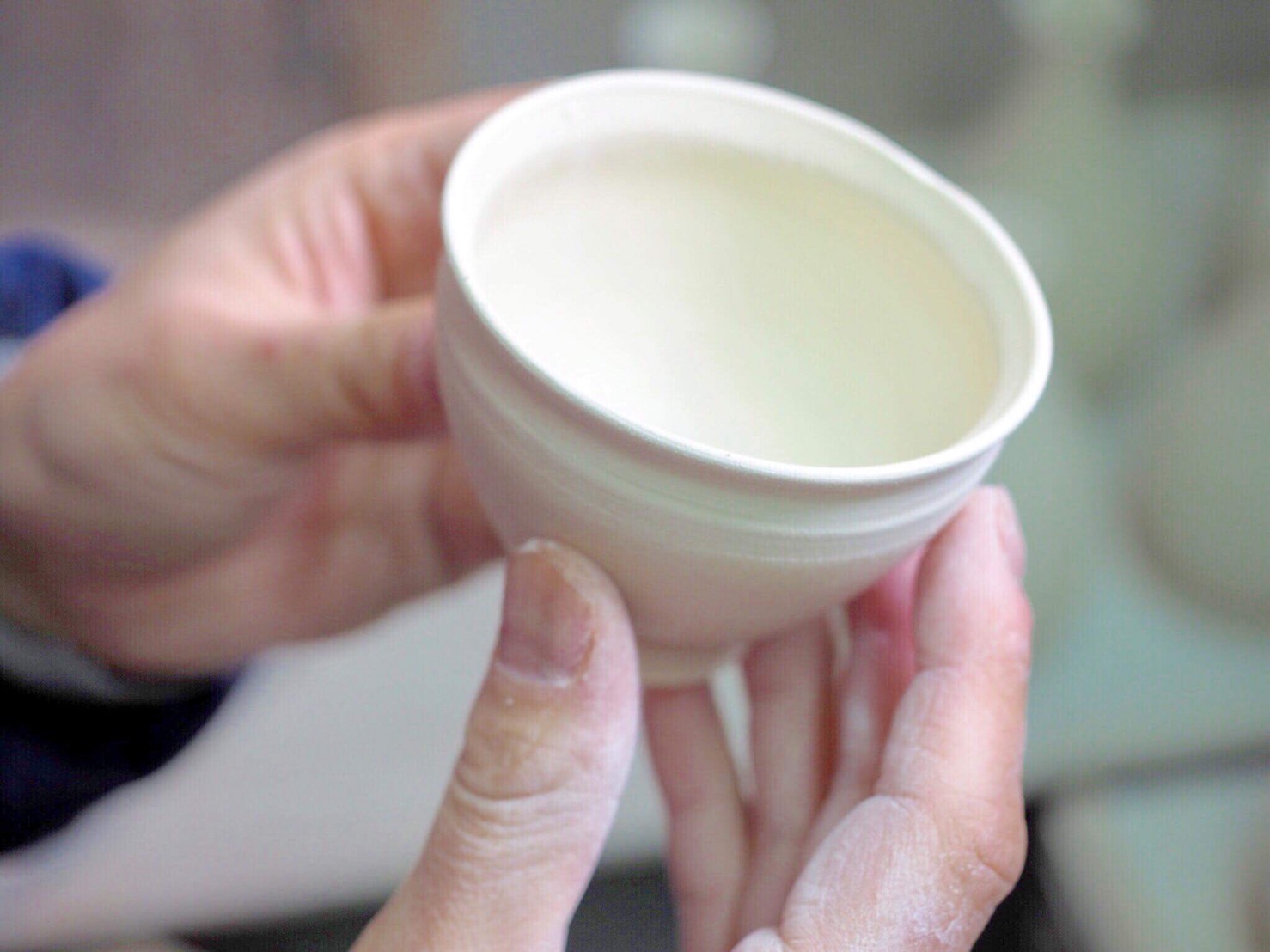 陶芸哲学者・馬場泰嘉が持つ、削りたての天目形ぐい呑の生生地。まだ「名もなき色」が宿る前の、石の理性が凝縮された純粋な肉体。1300度の炎が色彩を呼び覚ます直前の、静寂なる記録。