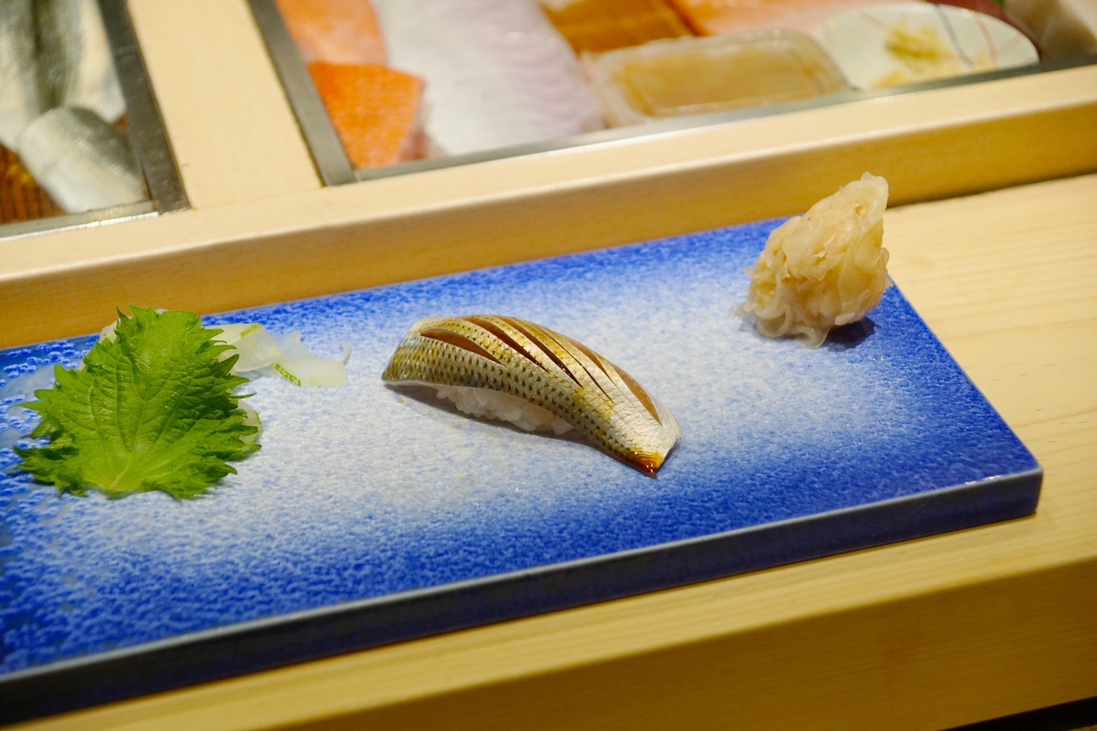 北新地『鮨 やまわき』に鎮座する、真右エ門窯の藍染水滴陶板。食の芸術と陶芸哲学が響き合い、共鳴者（Resonator）を深い静寂へと誘う「静かなる契約」の舞台。